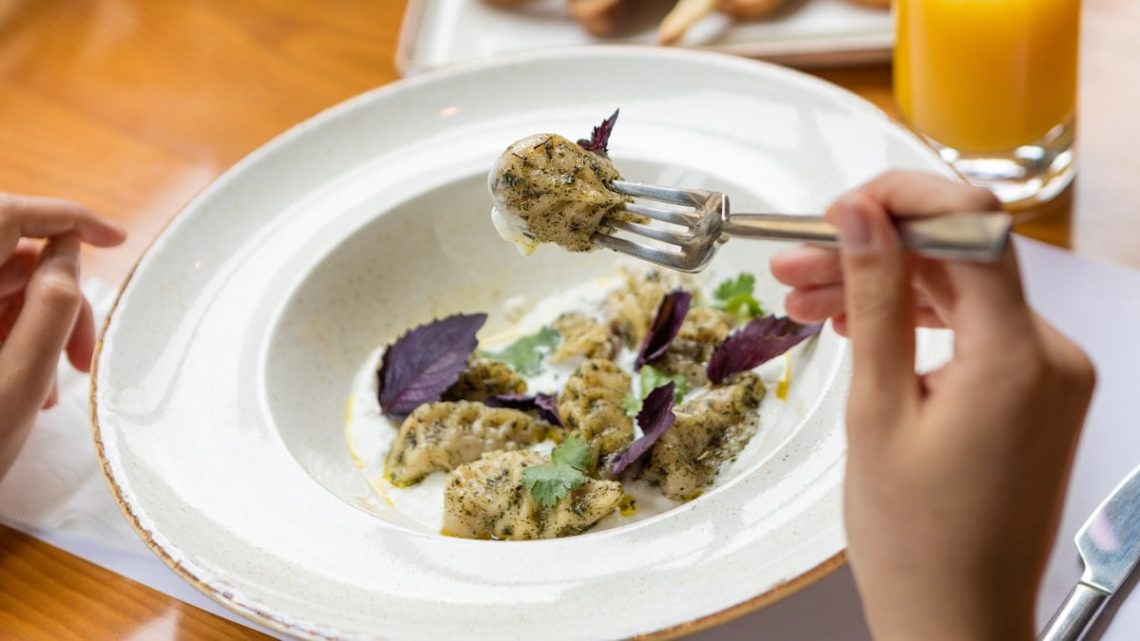 Tasty meat meal, a woman eating with a fork