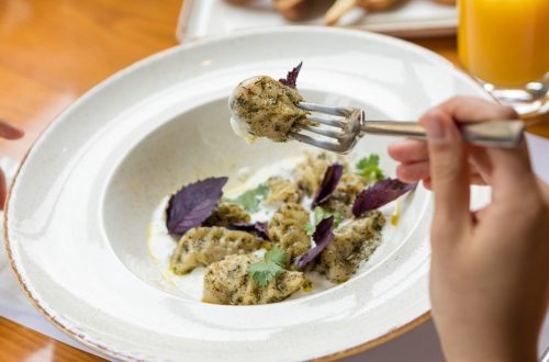Tasty meat meal, a woman eating with a fork